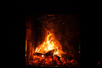 A fire burns in a fireplace, close up shot of burning firewood in the fireplace