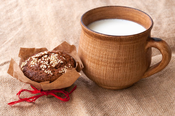 homemade brown clay cup with milk. on jute
