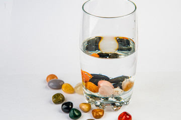 Glass with water and healing stones for Alternative Drink