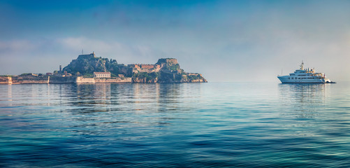 Fototapeta premium Panoramic morning view of old Venetian fortress in Kerkira, capital of Corfu island. Incredible summer seascape of Ionian Sea, Greece, Europe. Traveling concept background.
