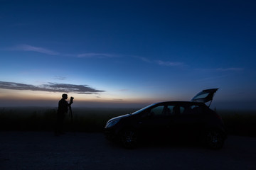 Fototapeta na wymiar photographer with the car in the field, night, backlight