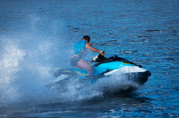 A Man on Jet Ski with much splashes. Water Sports. Vacation Concept.