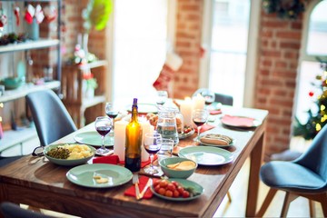 Setting of christmas table on festive holidays, full of traditional food with turky and delicious meals around the tree lights and decoration