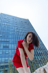 Fototapeta premium young woman in front of office building in red dres