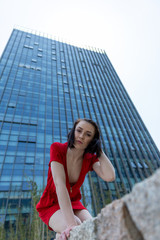 young woman in front of office building in red dres