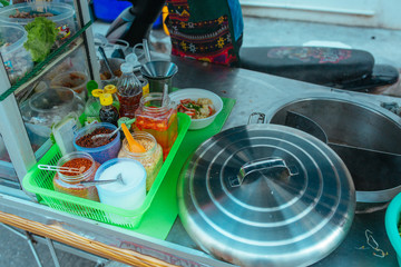 Street kitchen Pork soup with with noodles and herbs in Asia