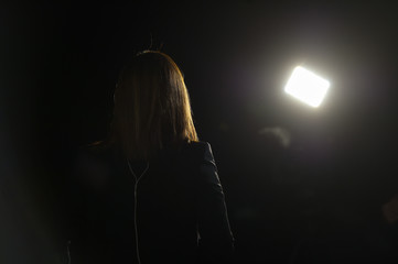 Journalist making a live broadcast in front of a spotlight