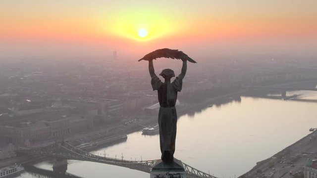 Budapest, Hungary, aerial view of historical landmark Liberty Statue and Budapest cityscape at sunrise.