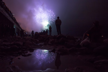 people on the background of fireworks, on the beach, the lights in the sky