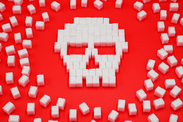 Sugar cubes laid out in shape of skull. Concept that sugar and sweets are dangerous. Sugar and...
