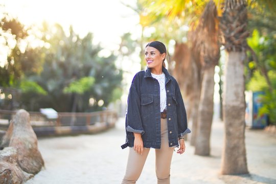 Young beautiful woman wearing denim jacket smiling happy and confident. Standing with smile on face at the town park