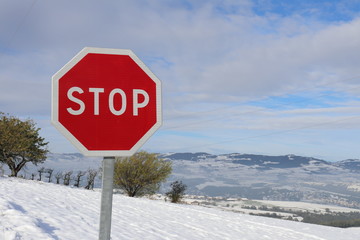 Panneau STOP - panneau de signalisation routière sur fond de paysage enneigé dans le massif du...