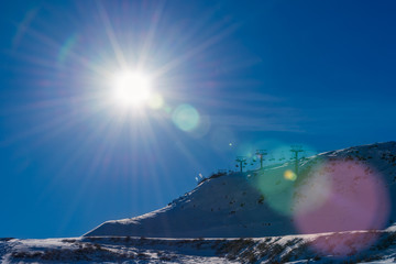 Snow lift under sun beam with flare effect