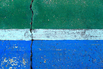 Cracked concrete floor with paint closeup for background.