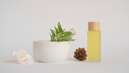 Fototapeta na wymiar aromatherapy oil with mortar and natural green leaf. for organic skincare and cosmetic.