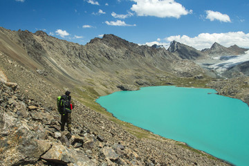 Fototapeta premium trekking in the mountains, trekking people with backpacks by the lake