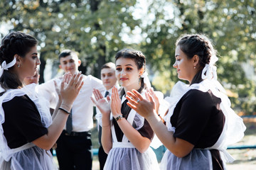 Three girls schoolgirls girlfriends, teenagers laugh rejoice. Rest after lessons school college. Three girls in school uniform. Back to school. Happy girls relax after school emotions joy delight