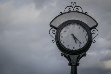 Fototapeta na wymiar Town clock in frisco, colorado. Beautiful vintage street clock in black color on a dull gray day.