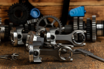 Fototapeta na wymiar high performance motorcycle engine parts on a workbench. pistons connecting rods clutch and tools 