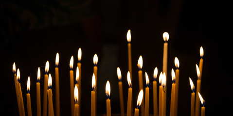 burning candle decoration against black background