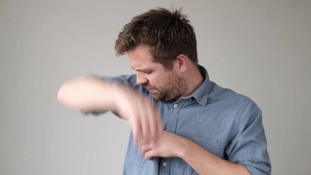 Young man in blue shirt with sweat spot on it.
