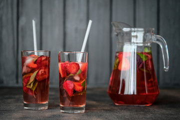 Fototapeta na wymiar Homemade strawberry lemonade with basil on a dark background.