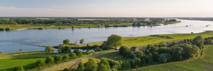 Panoramaaufnahme einer holländischen Landschaft mit dem Fluss Waal in der Nähe des Dorfes Herwijnen © Marc Molenaar/Wirestock