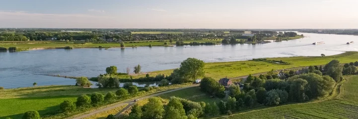 Panoramaaufnahme einer holländischen Landschaft mit dem Fluss Waal in der Nähe des Dorfes Herwijnen © Marc Molenaar/Wirestock