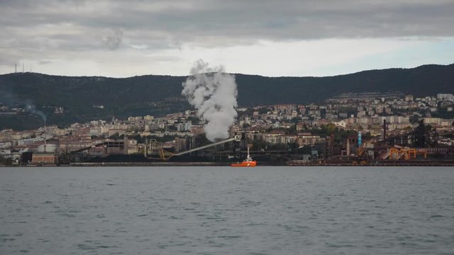 Industrial zone in Trieste city over bay seen from Muggia, Italy