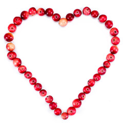 Obraz premium Heart made of ripe cranberries isolated on a white background. Top view.