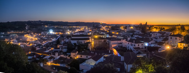 Sunset view of the old town walls, decorated for Christmas, in Obidos, Portugal