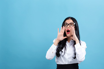 Young woman shouting on a blue background