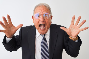 Senior grey-haired businessman wearing suit and glasses over isolated white background celebrating crazy and amazed for success with arms raised and open eyes screaming excited. Winner concept