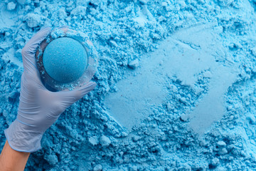 Blue bath bomb in hand, manufacture process