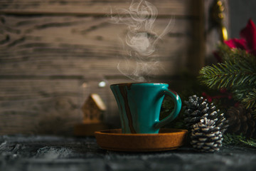Coffee smoke cup, fir branch, pine cones, glass ball on dark rustic backdrop. For Christmas, new year winter holiday drink, beverage. Festive template, copy space, shallow depth of field