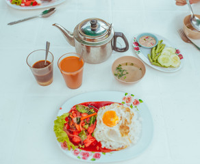 Omelet with vegetables, thai tea and soup on the table