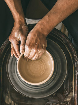 Pottery workshop Top view Man is sculpting a bowl behind a rotating potter's wheel