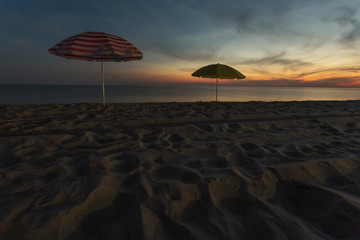 beach umbrellas at night by the sea