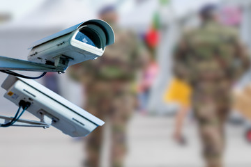 CCTV camera concept with soldiers on patrol on background