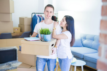 Young beautiful couple moving cardboard boxes at new home