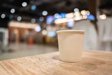 A cup of tea paper placed on a wooden table with free space