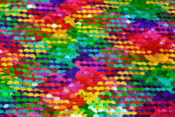 Multicolored macro sequin background. Selective focus.