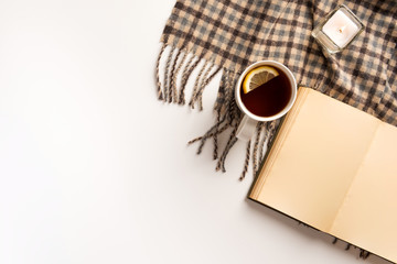 Autumn, cozy composition. Cup of tea, warm scarf, book, isolated on white background. Flat lay.