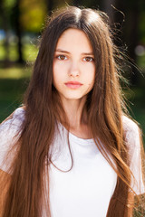 Naklejka premium Close up brunette girl in summer park background
