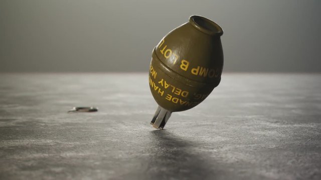 Threw lemon M26 hand grenade rotating on concrete floor with safety pin. 4k HD