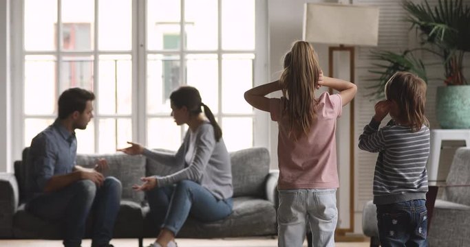 Unhappy parents arguing fighting while sad innocent children closing ears