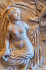 Statue of beautiful young woman breast naked carved on marble wall