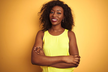 Young african american woman wearing t-shirt standing over isolated yellow background happy face...
