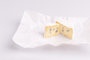 Blue cheese with white surface, isolated on white background, soft light, studio photo. Mix of gorgonzola and camembert / brie cheese.