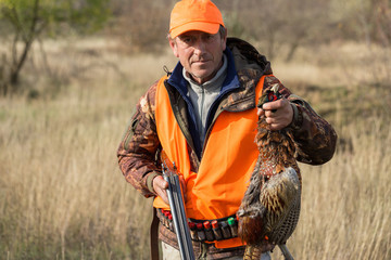 Hunting period, autumn season open. A hunter with a gun in his hands in hunting clothes in the...